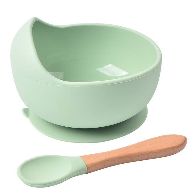 a green bowl with a wooden spoon on a white background