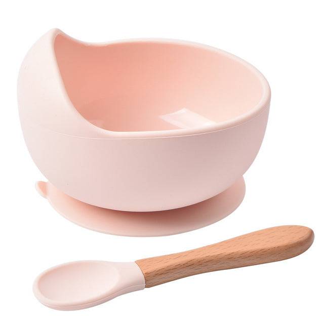 a pink bowl with a wooden spoon next to it
