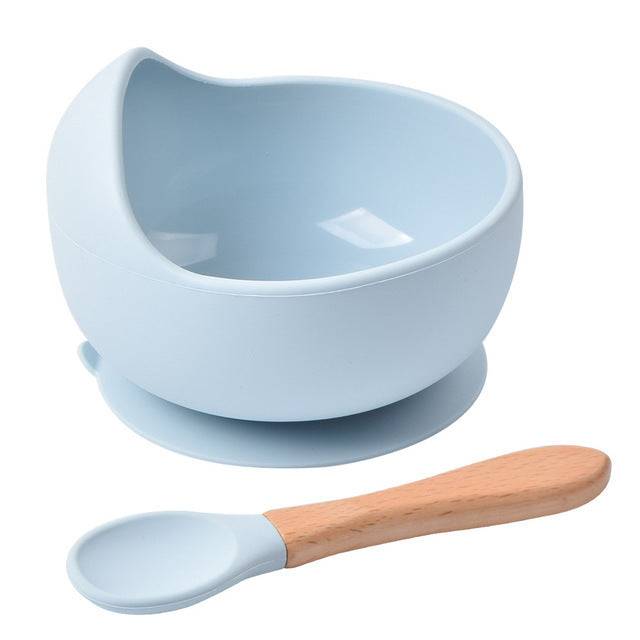 a white bowl with a wooden spoon next to it