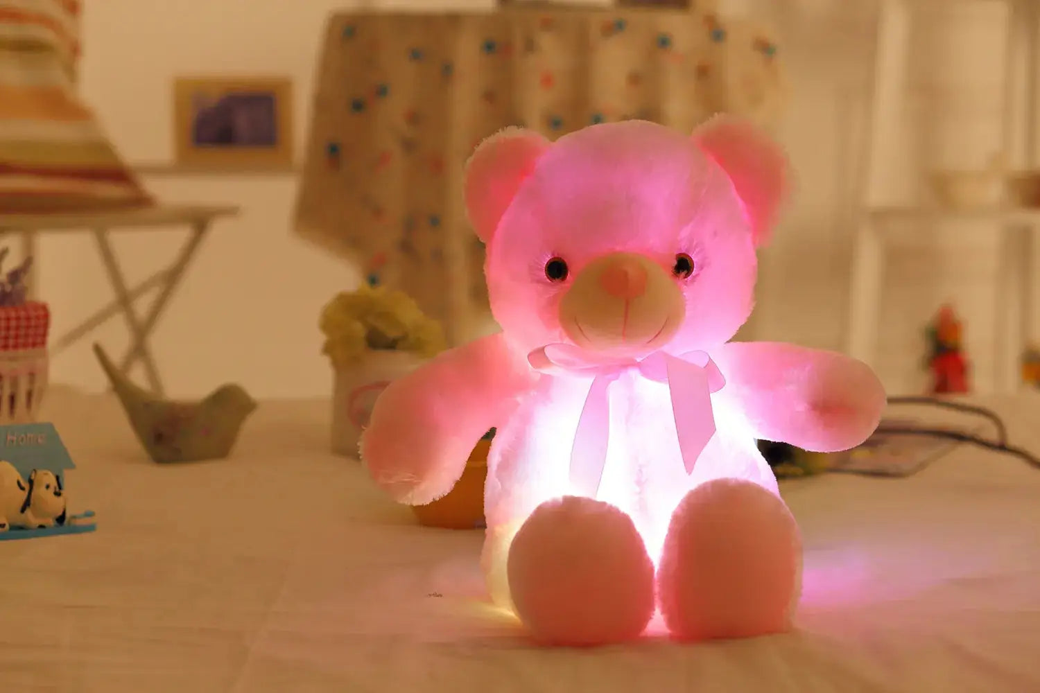 a pink teddy bear sitting on top of a bed