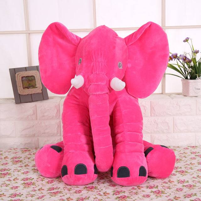 a large pink stuffed elephant sitting on a table