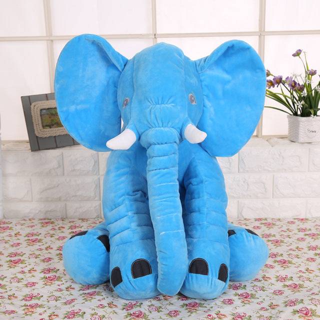 a large blue stuffed elephant sitting on top of a table