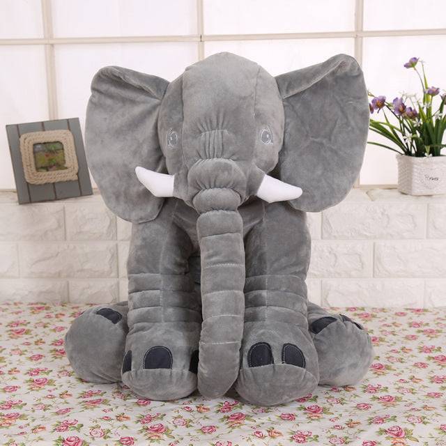 a large stuffed elephant sitting on top of a table