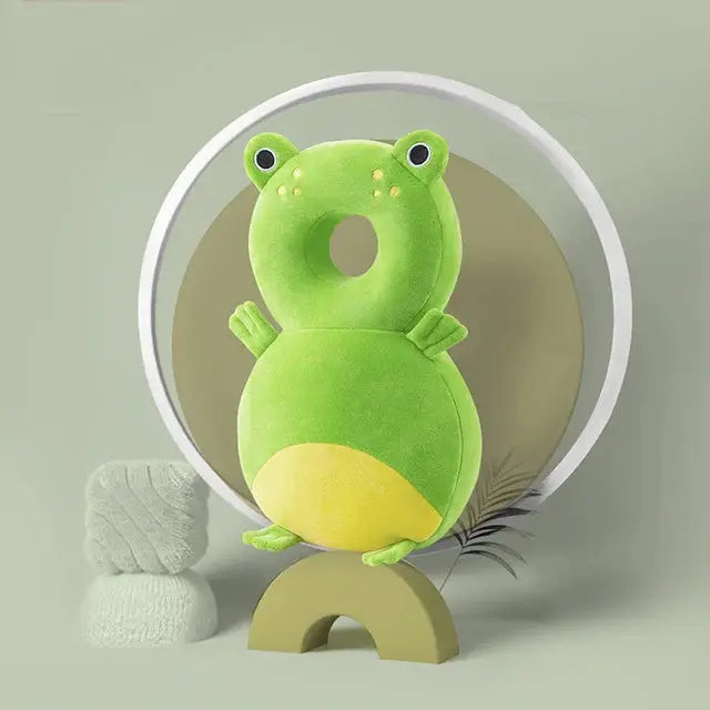 a green frog stuffed animal sitting in front of a round object