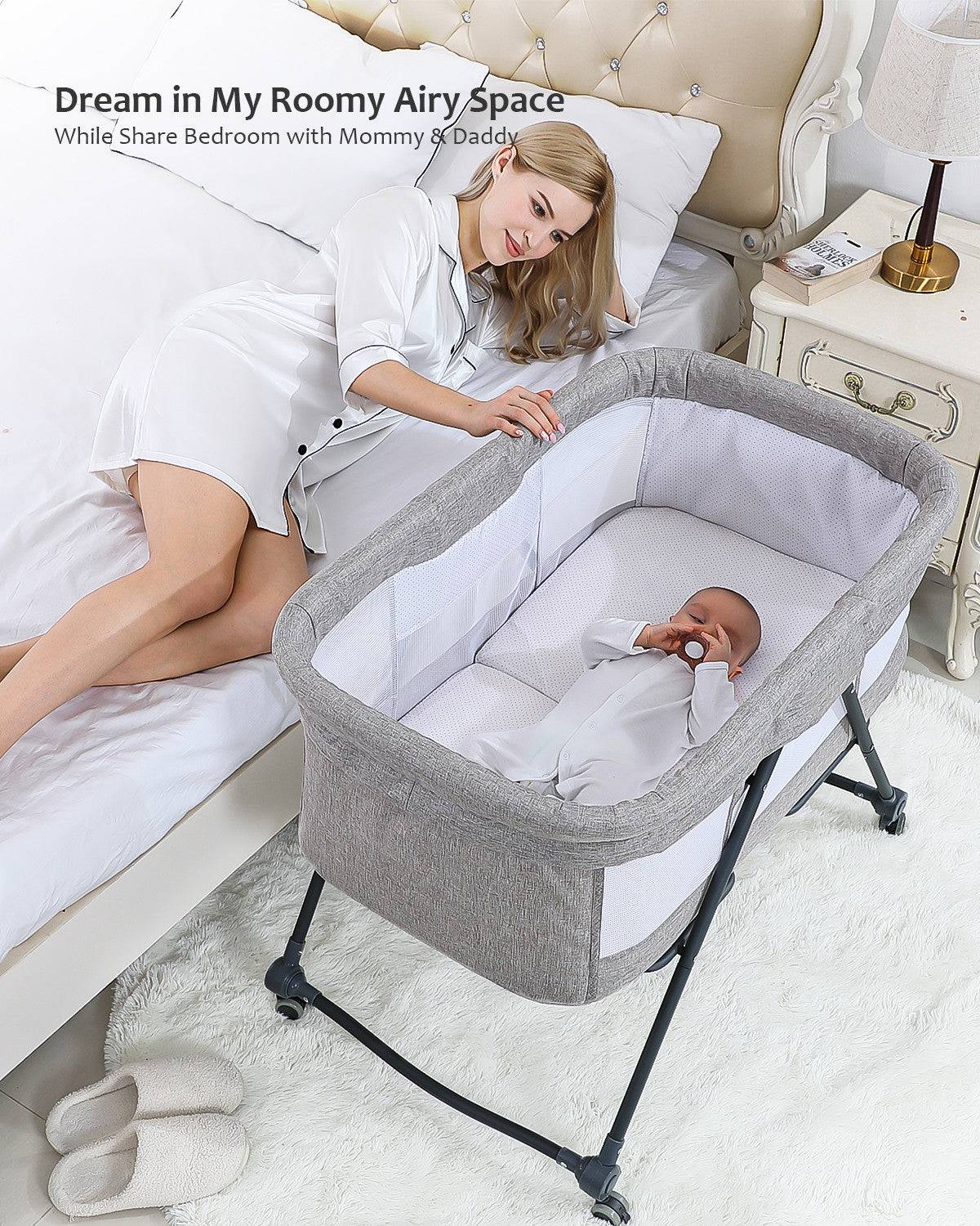 a woman laying in bed next to a baby in a crib