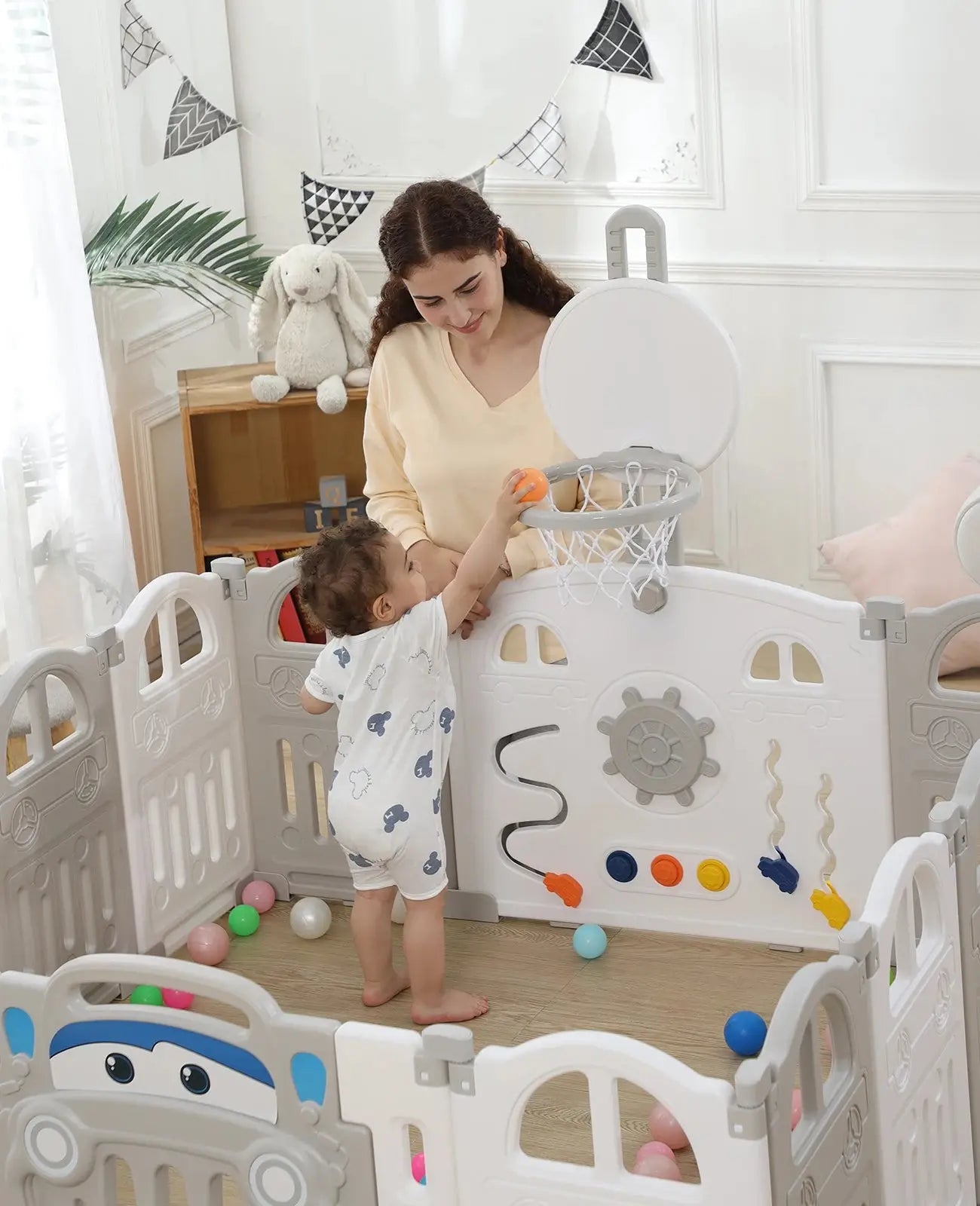 a woman and a child playing in a playpen