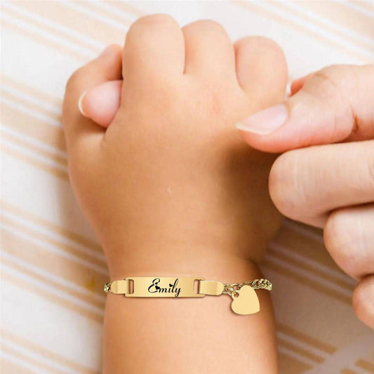 a person wearing a gold bracelet with a heart on it