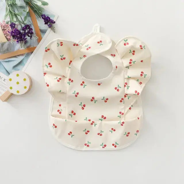 a baby bib with a cherry print on it