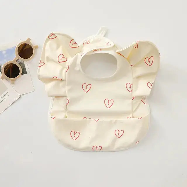 a baby bib with a pair of sunglasses next to it